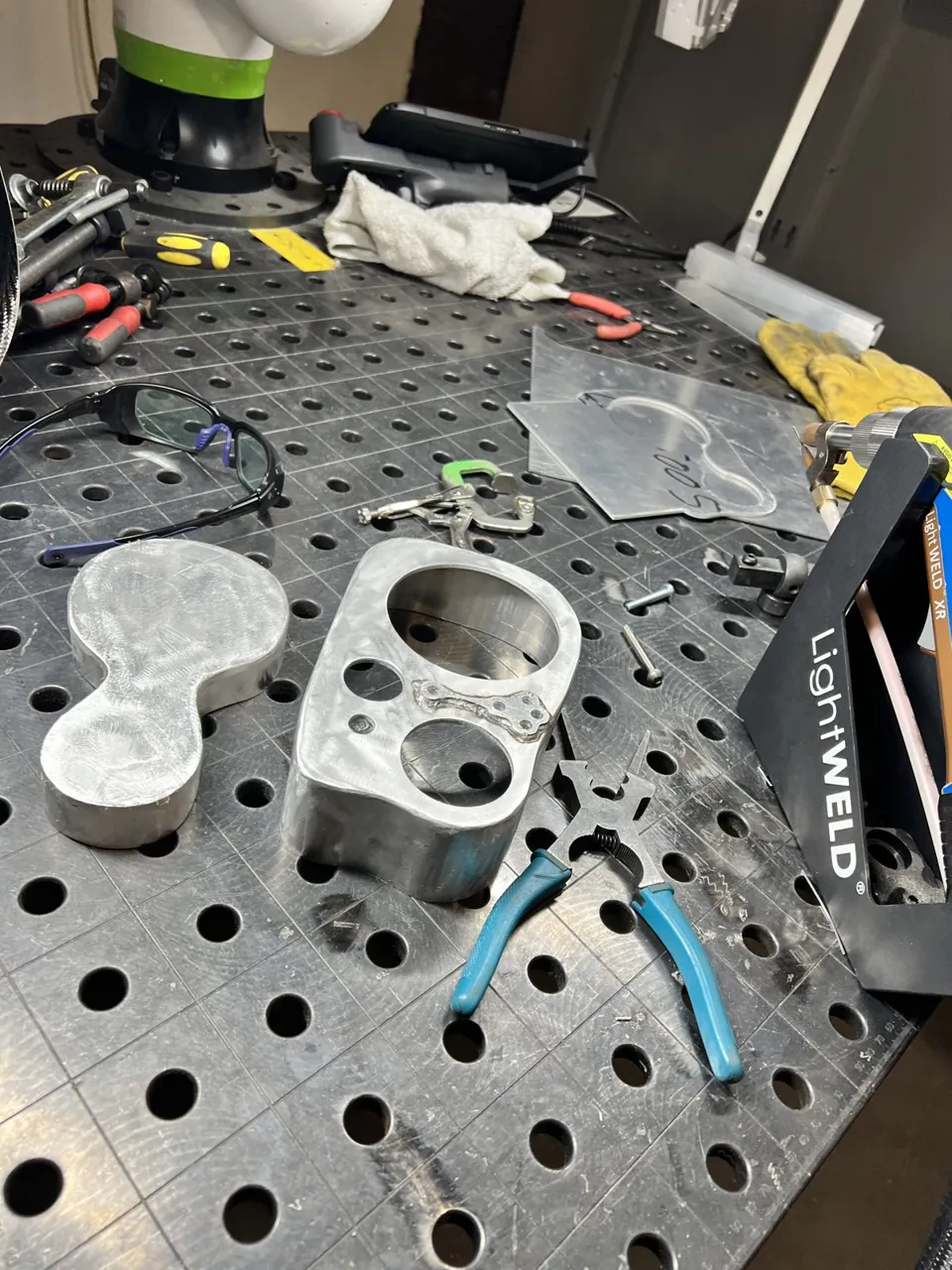 Printed parts for a new speedometer housing on the workbench pegboard