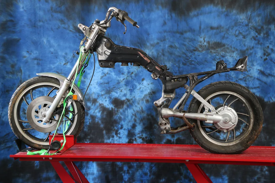 Una Yamaha Virago desmantelada en un elevador, sin motor, lista para el sistema Multi-Fit.