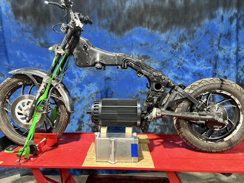 A Yamaha Virago frame on a lift with the engine out and the electric motor and controller mocked up where the V-Twin sat.
